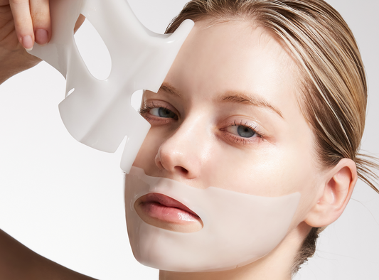 Model applying hydrogel collagen face mask sheet to fix cakey makeup and dehydrated skin
