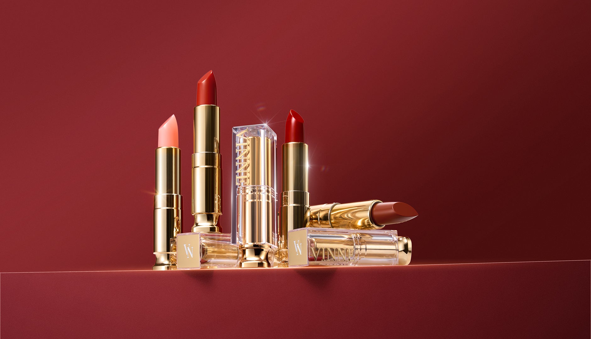 Set of lipsticks with gold cases on a red background