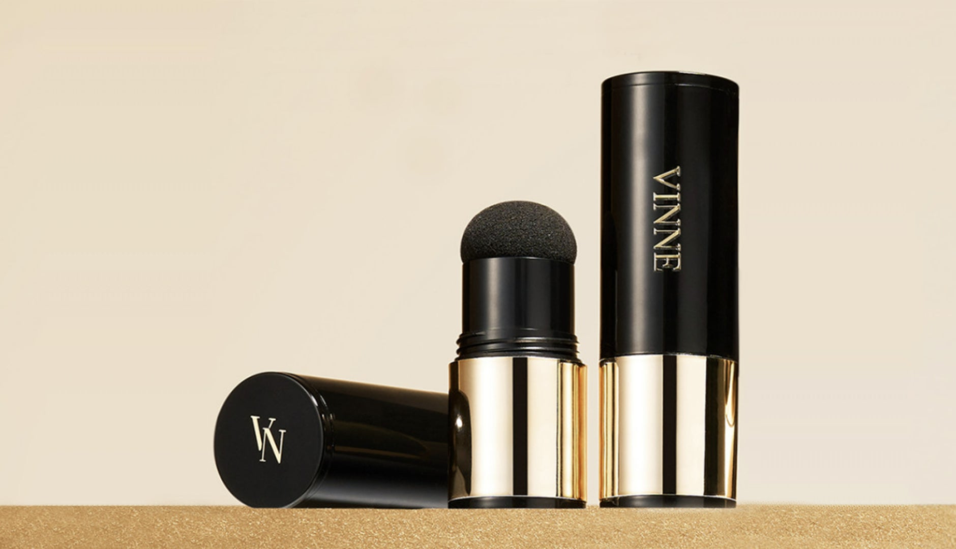 Makeup stick with black and gold design and 'VINNE' branding on a beige background
